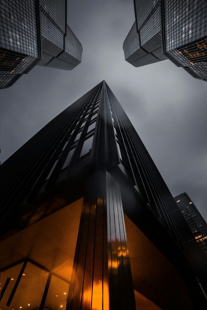 pexels-photo-1707823-1707823 A low angle view of skyscrapers reaching into a moody night sky, showcasing modern architecture.